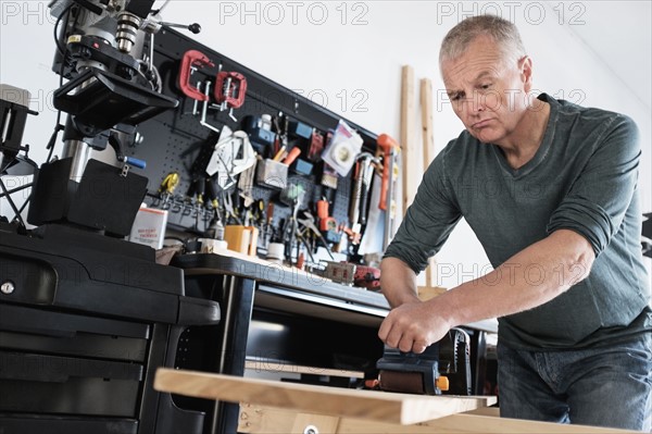 Man working with wood in home workshop.