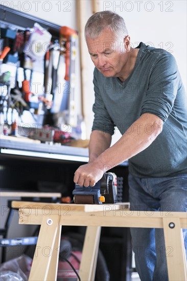 Man working with wood in home workshop.