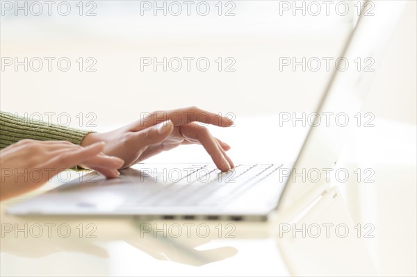 Hands typing on laptop keyboard.