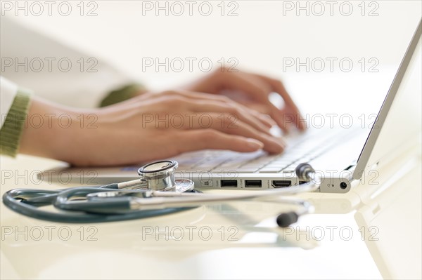 Hands typing on laptop keyboard.