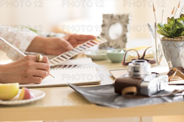 Young woman writing in note pad.