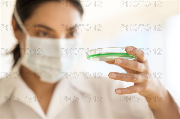 Scientist holding petri dish.