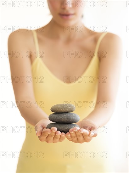 Woman holding stack of pebbles.