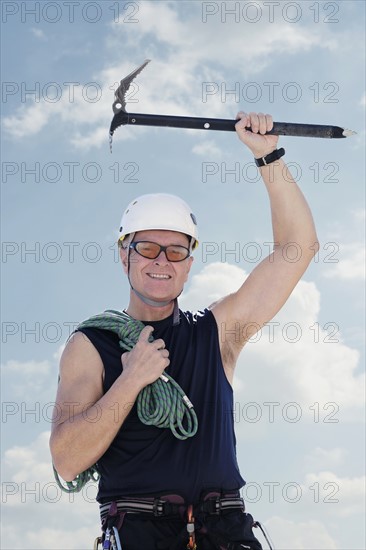 Portrait of man with climbing equipment outdoors.