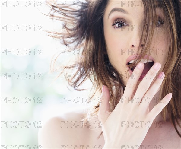 Portrait of surprised beautiful woman with brown hair.