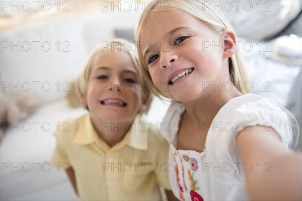 Girl (6-7) and boy (4-5) looking at camera