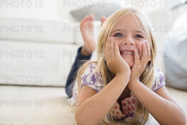 Girl (6-7) lying on floor