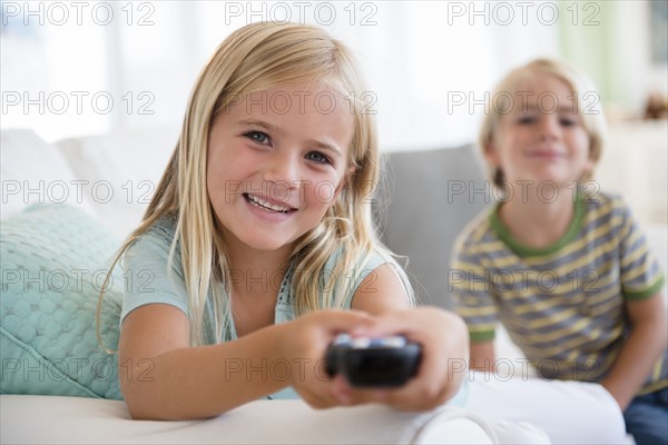 Boy (4-5) and girl (6-7) sitting on sofa