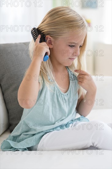 Girl (6-7) brushing hair