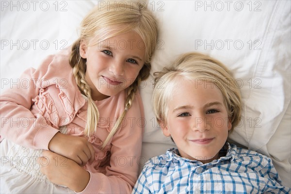 Boy (4-5) and girl (6-7) looking at camera