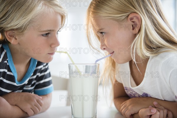 Brother (4-5) with sister (6-7) drinking milk from glass