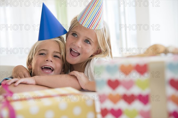 Brother (4-5) and sister (6-7) in embrace at birthday party