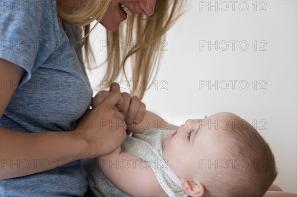 Mother holding hands of baby daughter (12-17 months)