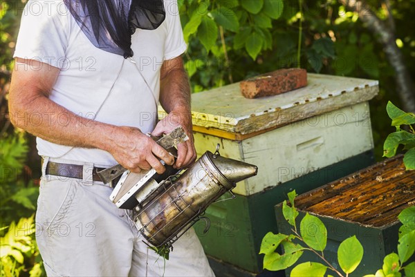 Beekeeper holding smoker