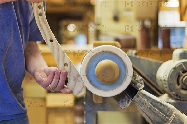 Carpenter polishing wood with sander