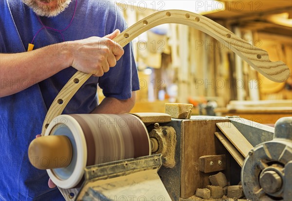 Carpenter polishing wood with sander