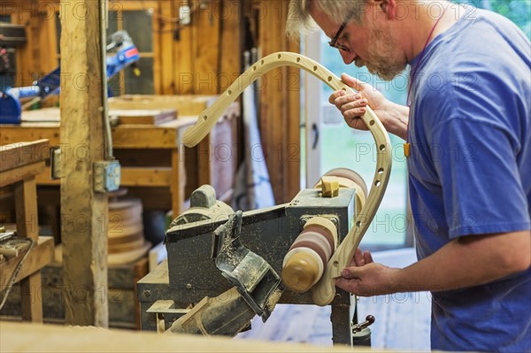 Carpenter polishing wood with sander