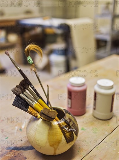 Brushes in bowl in art studio