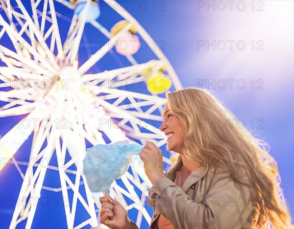 Woman holding cotton candy at funfair