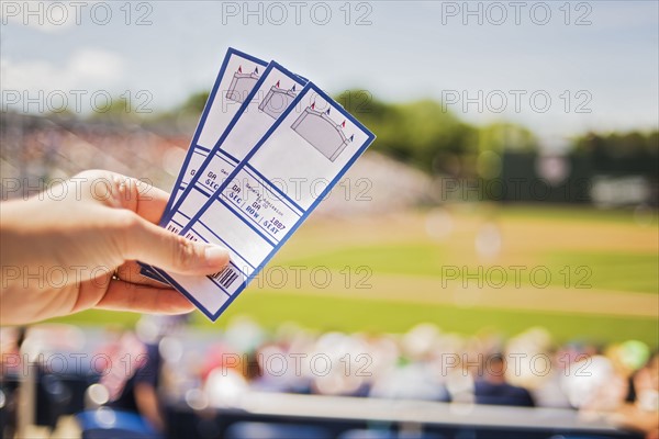 Close-up of hand holding tickets at stadium