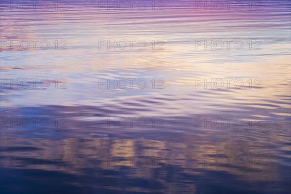 Rippled water reflecting colorful light