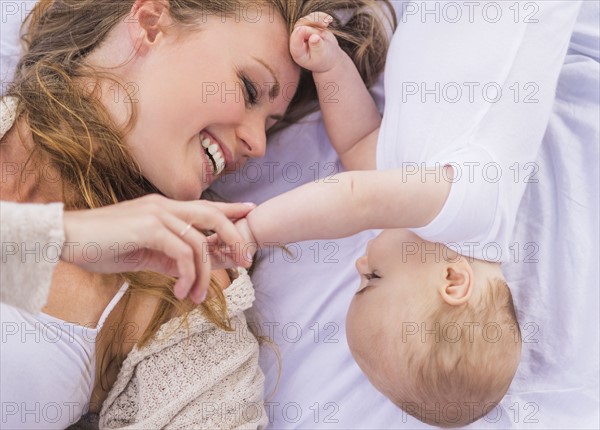 Mother and baby (6-11 months) lying down and playing