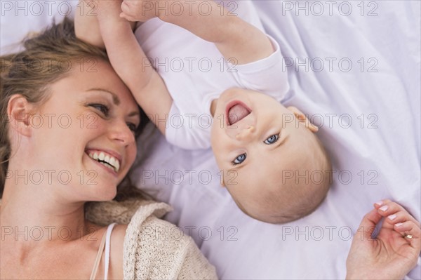 Mother and baby (6-11 months) lying down and playing