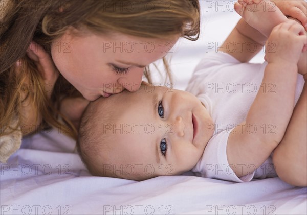 Mother kissing baby (6-11 months)
