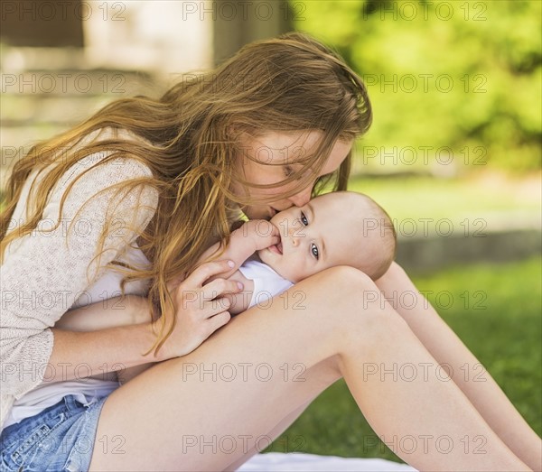 Mother kissing baby (6-11 months)