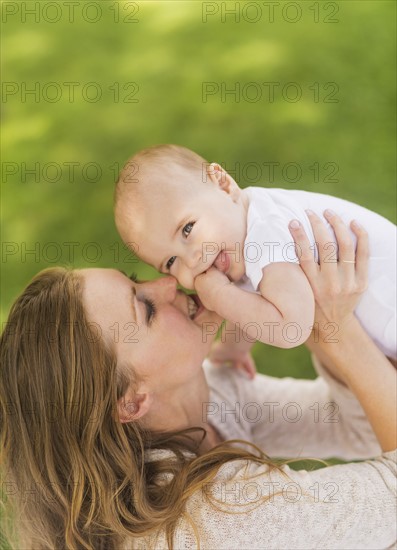 Mother holding up baby boy (6-11 months)