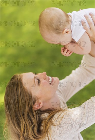 Mother holding up baby boy (6-11 months)