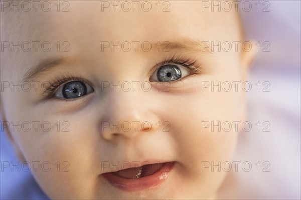 Close-of baby boy's (6-11 months) smiling face