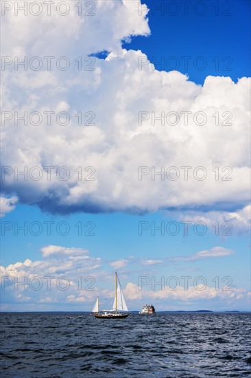 Sailboat on sea and Rockland Harbor Breakwater Lighthouse in distance