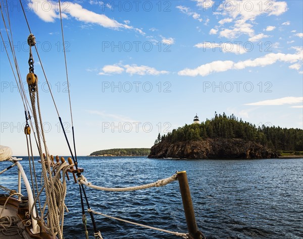 Lighthouse on cliff seen from sailboat
