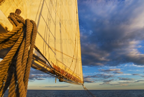 Sail and ropes against sunset sky