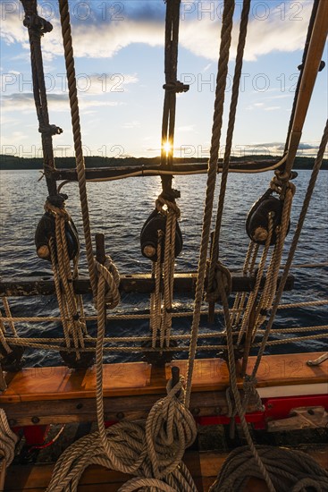 Ropes on sailboat against sunset sky