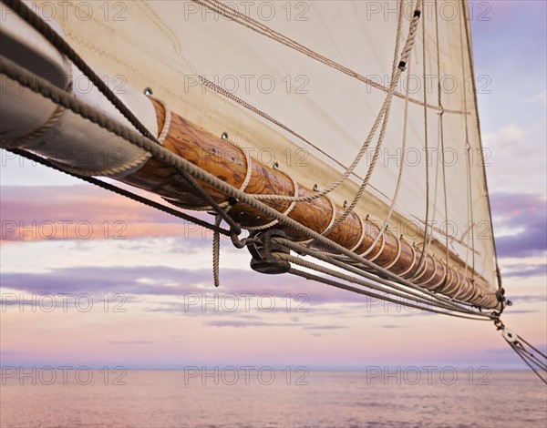 Close-up of sail and ropes against sunset sky