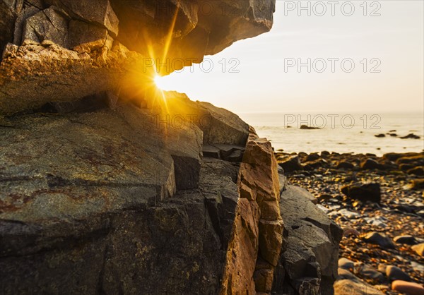 Rock formations on beach and sea at sunrise