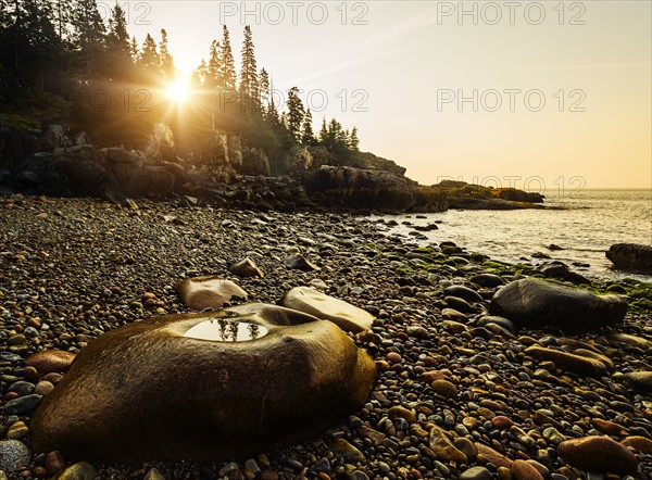 Rocks and pebbles on beach at sunrise