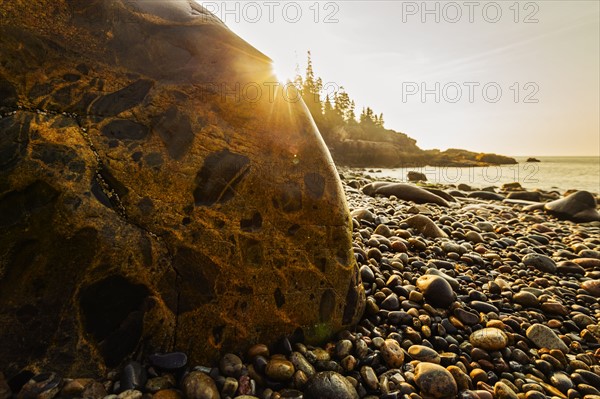 Rocks and pebbles on beach at sunrise