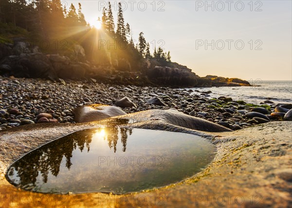 Rocks and pebbles on beach at sunrise