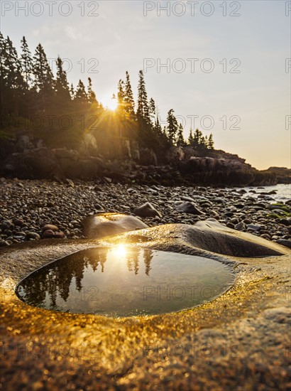 Rocks and pebbles on beach at sunrise