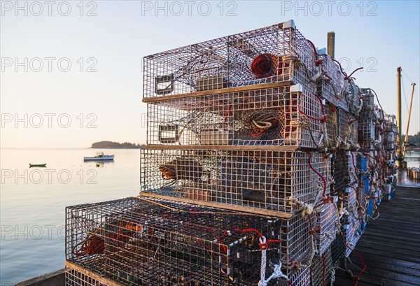 Stacks of lobster traps at sunrise