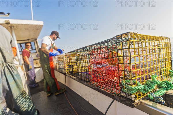 Three fishermen working on boat