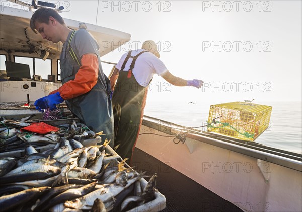 Two fishermen working on boat