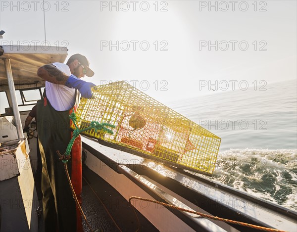 Fishermen throwing lobster trap