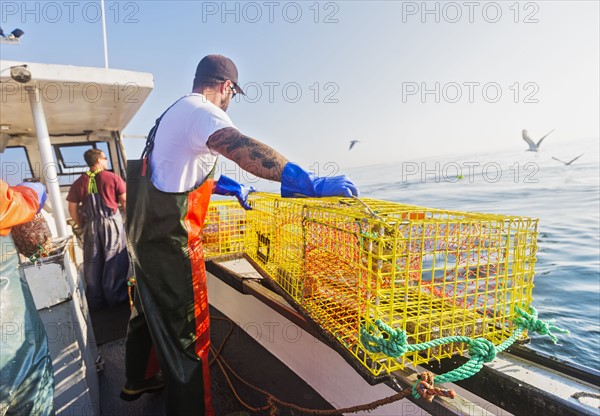 Three fishermen working on boat