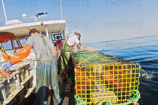 Three fishermen working on boat