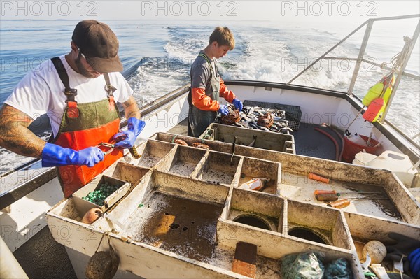 Two fishermen working on boat