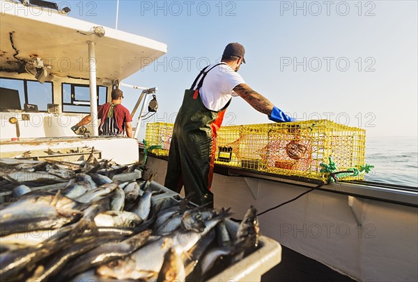 Two fishermen throwing lobster traps